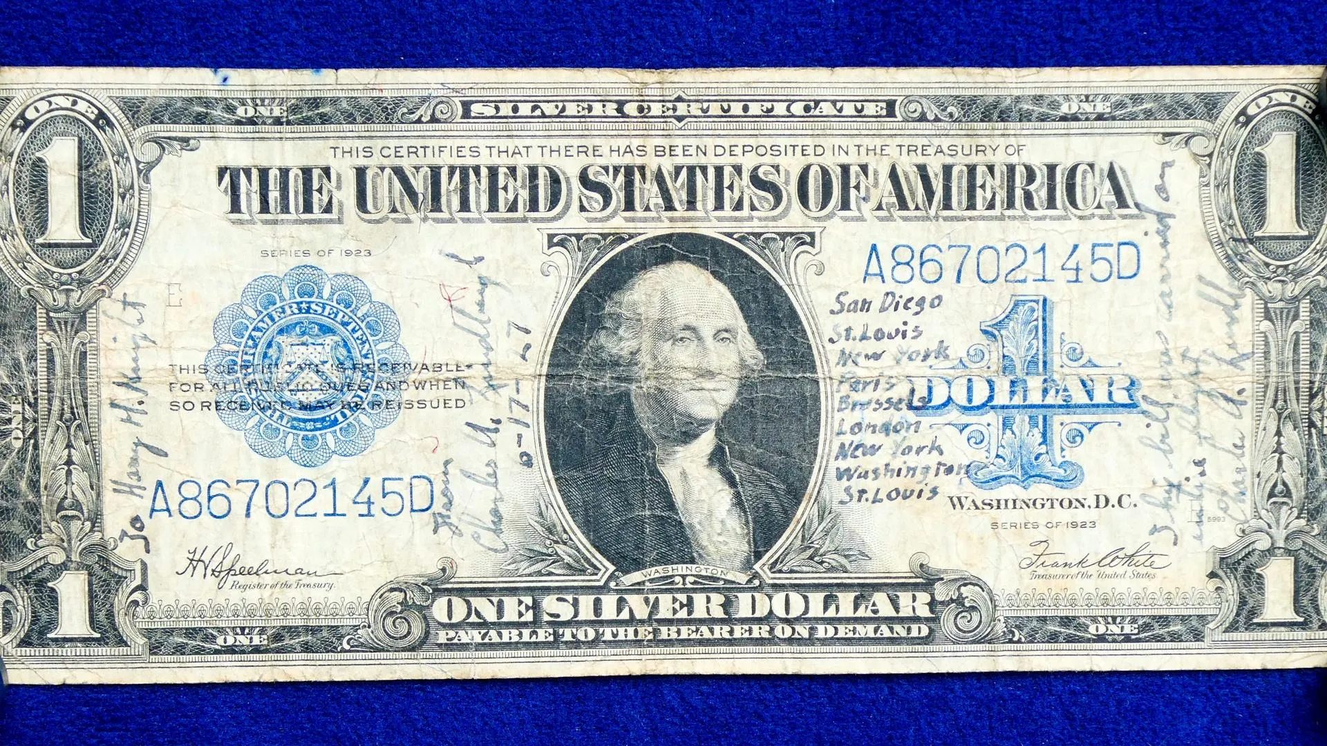 A dollar bill with blue stamps and small writing in ink.