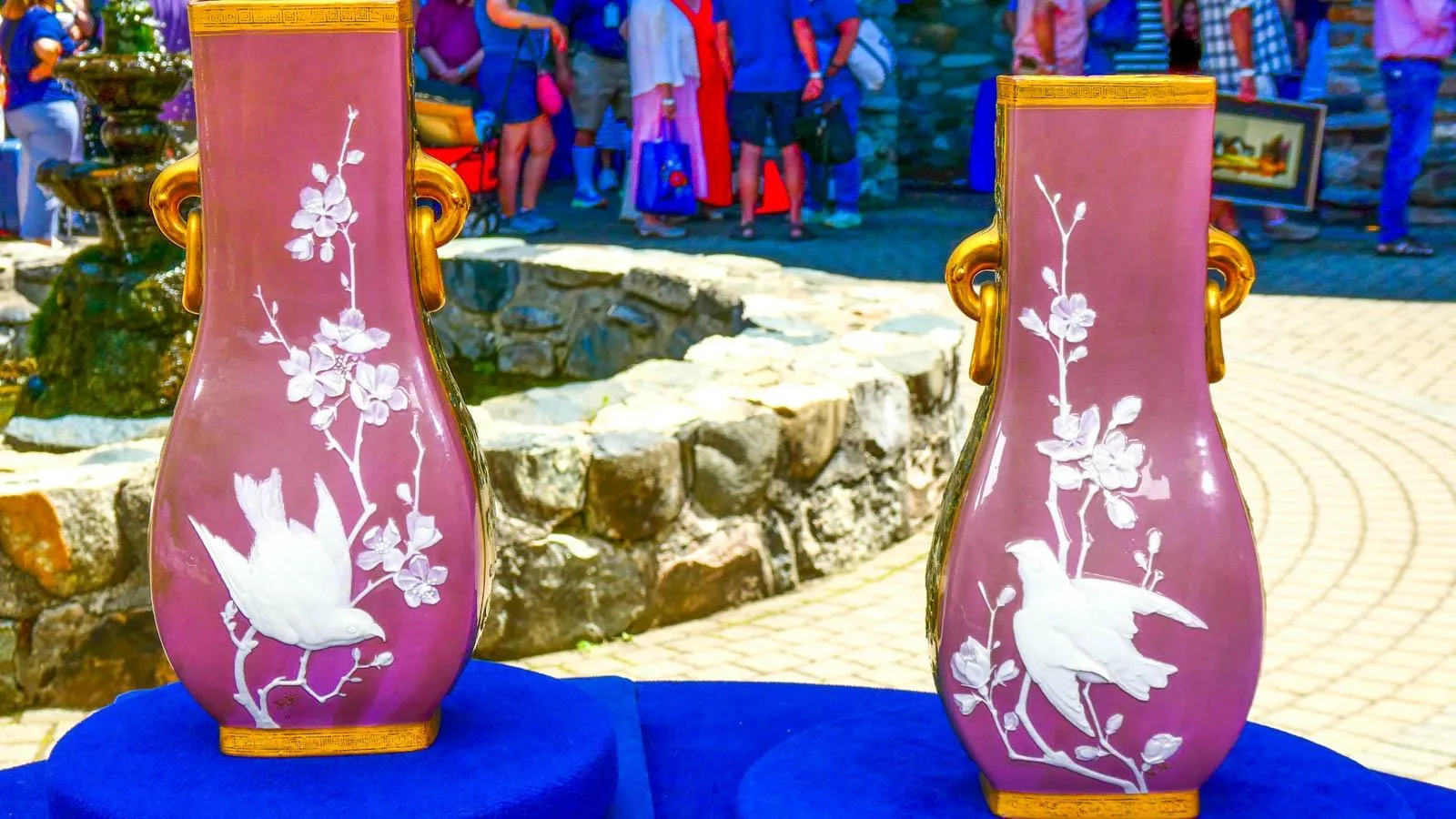 Two purple vases with floral and bird details sit side by side on the table.