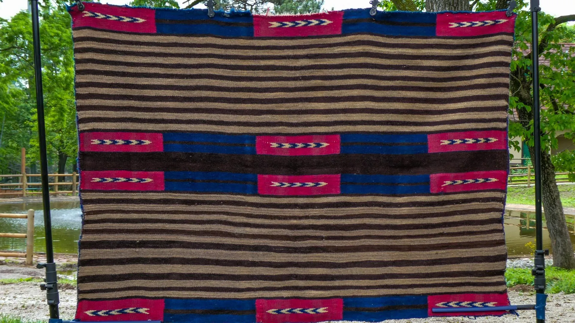 A blue, black, and purple tribal print blanket stretched out display the full item.