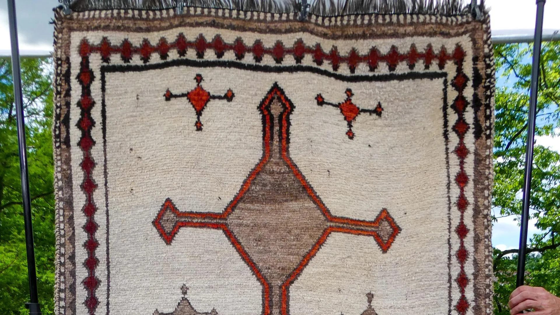 Close up on a rug  with orange black and brown detailing.