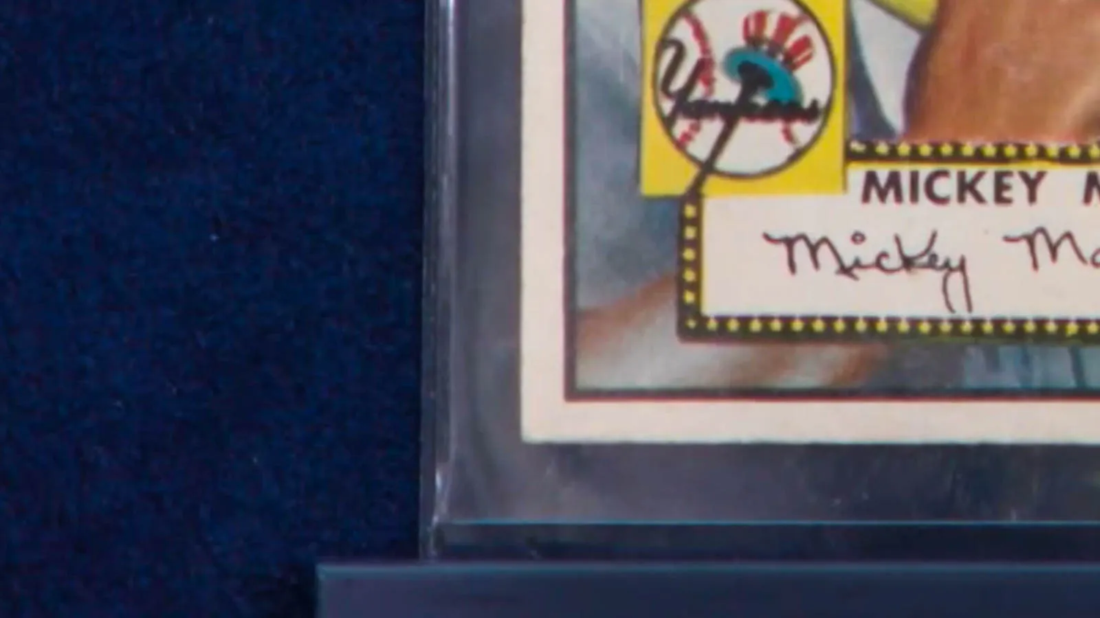 Close-up of the lower left corner of a 1952 Mickey Mantle Topps rookie baseball card, showing slight wear