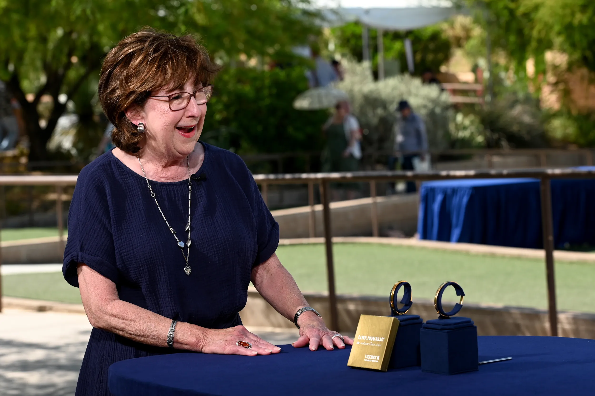 A guest smiles in reaction to the appraisal of her two gold bracelets.