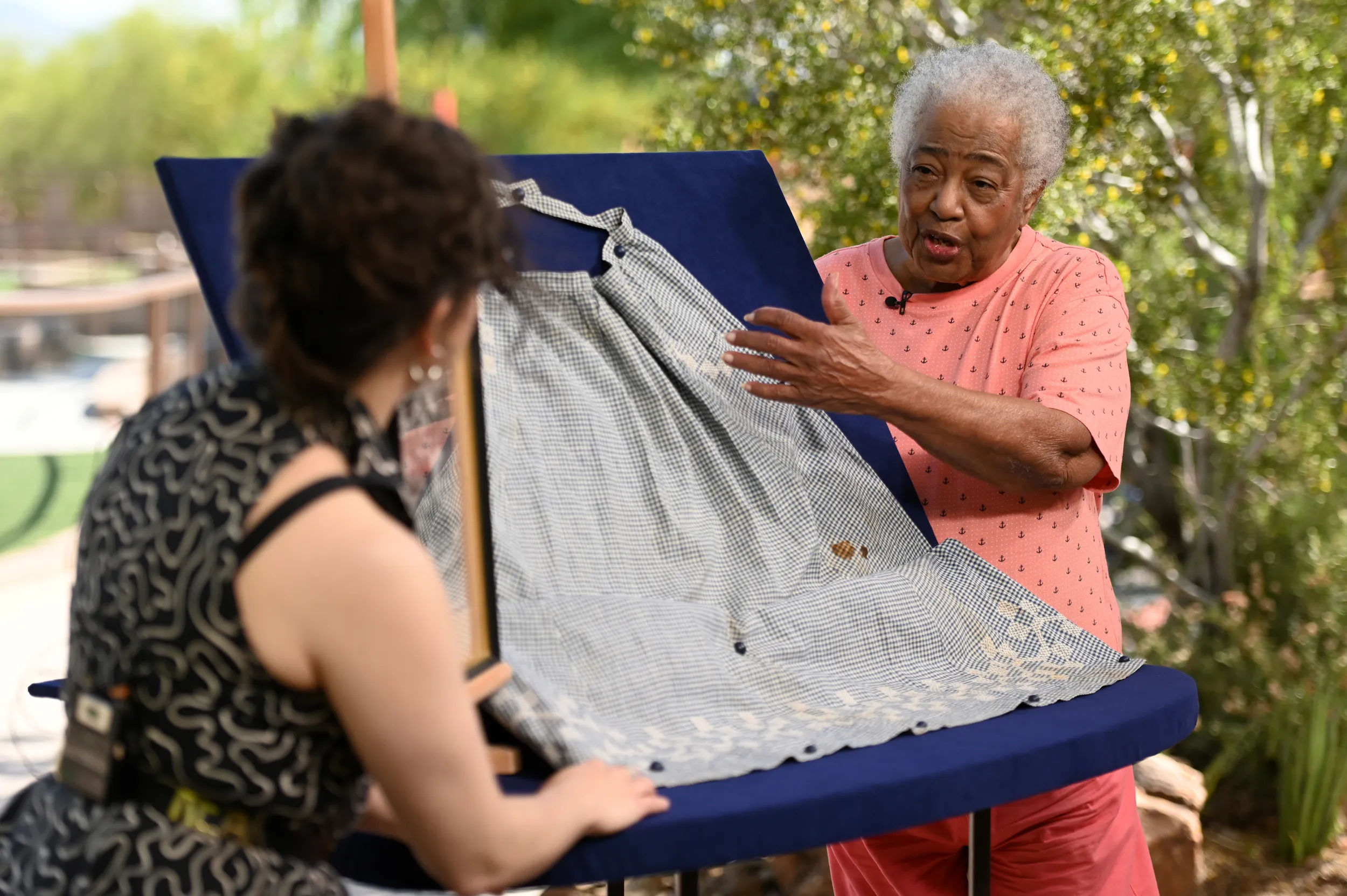 A guest display's her apron on an appraisal table, as an appraiser reviews for the cameras.