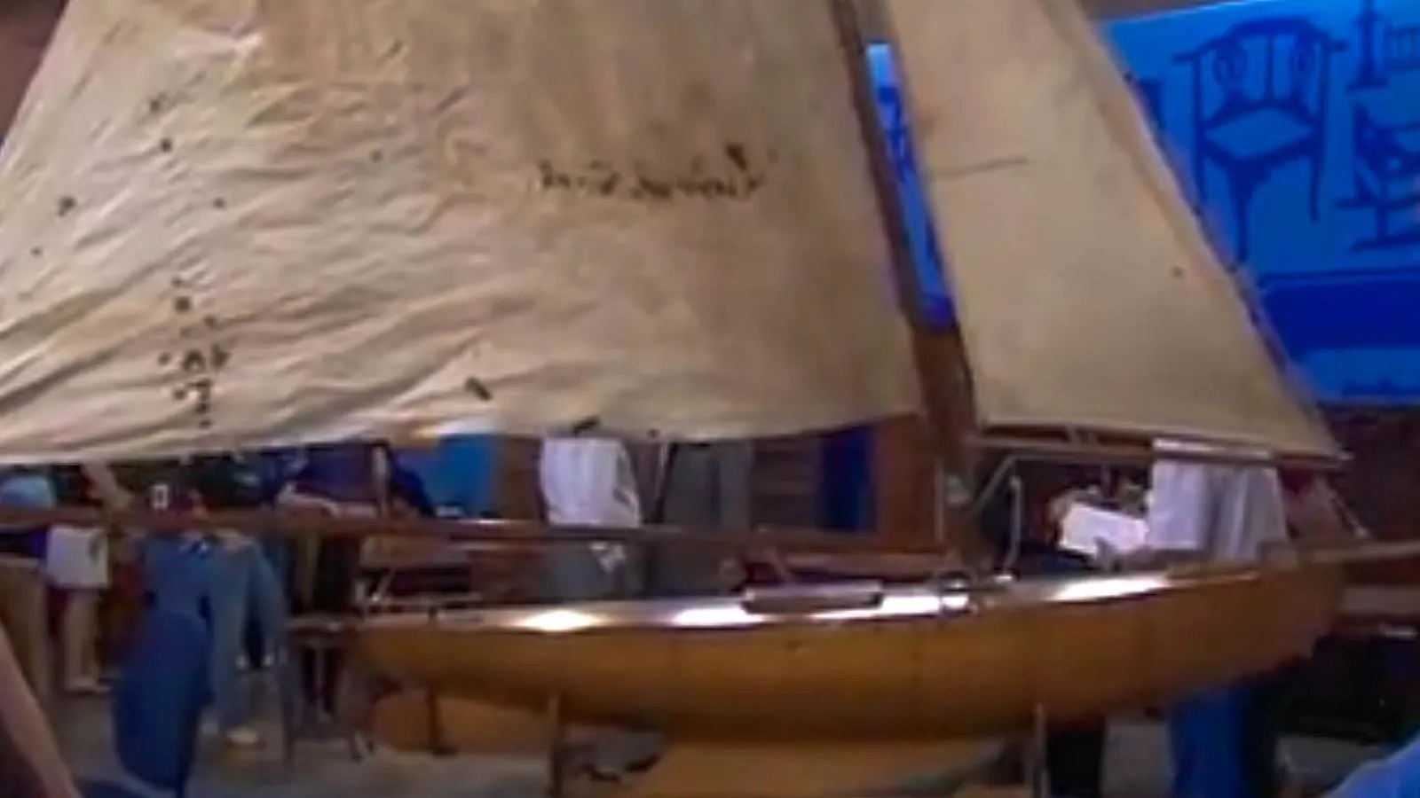 Wooden pond yacht with off-white colored sails.