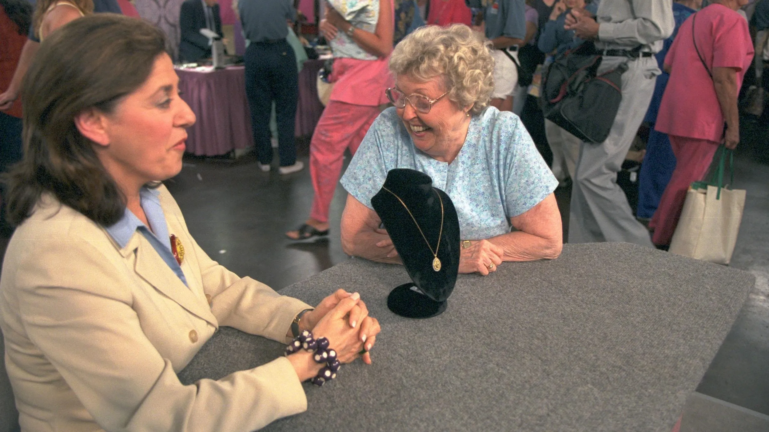 Photo of two women seated smiling in conversation