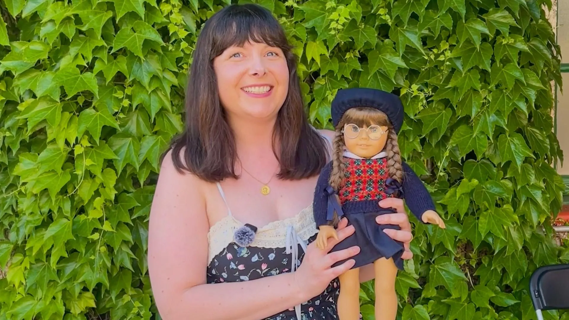 Photo of a smiling woman holding a Molly doll