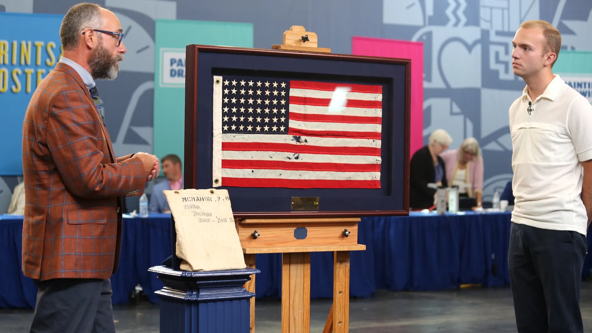 Appraiser Jeff Shrader and guest with framed U.S. flag