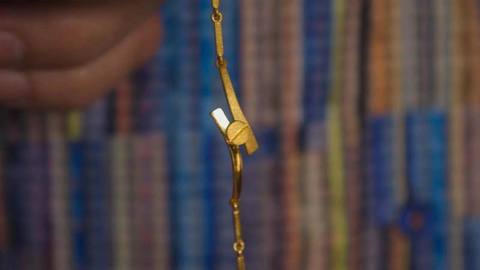 Close up of gold bracelet with screw design.