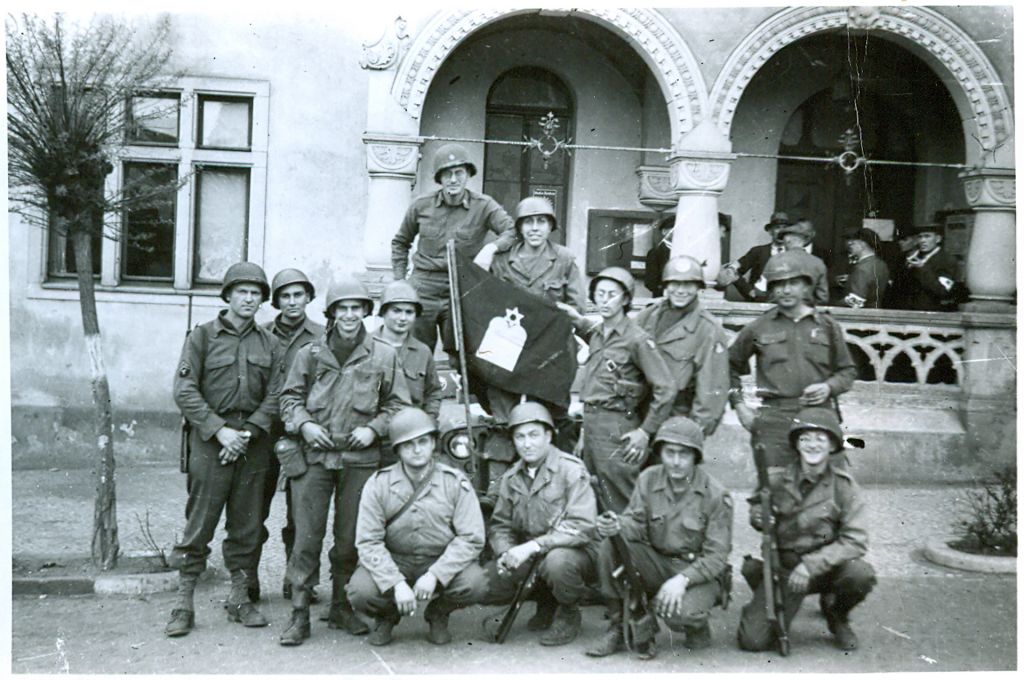 Group around Jewish chaplain's flag. Written on back: "end of war for 104th Inf. 1945."