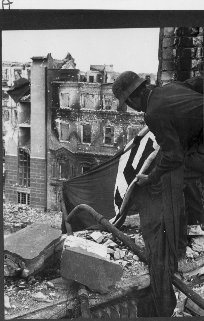 German soldier hands flag in downtown Stalingrad, autumn 1942. 