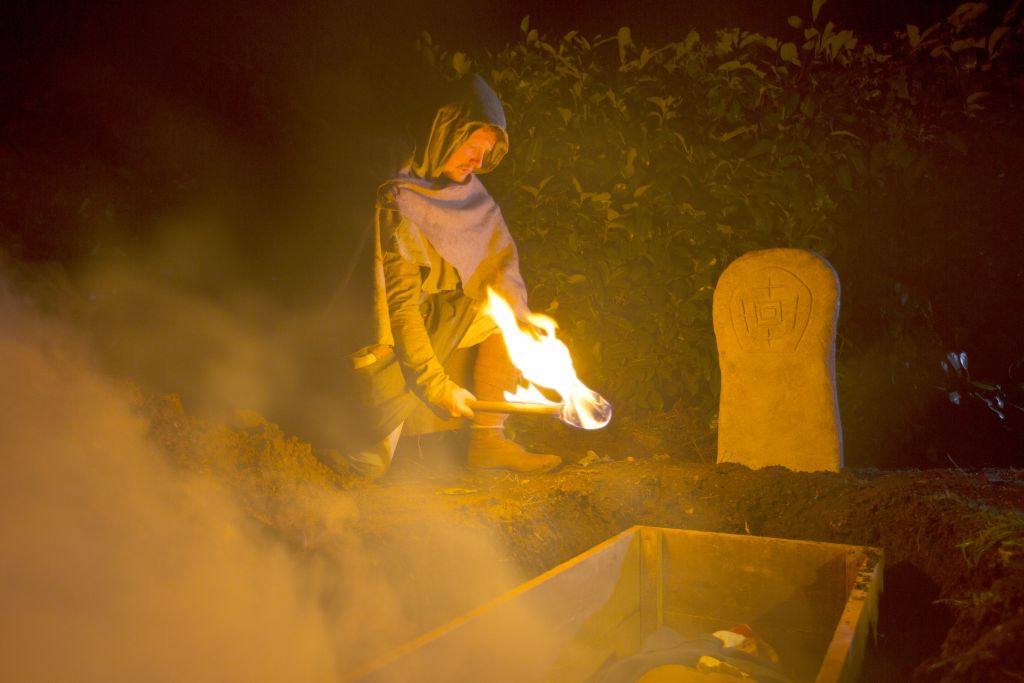 Dramatic re-enactment, Saxon/early medieval man find the "vampire's" body in tact with blood on the shroud at the mouth.