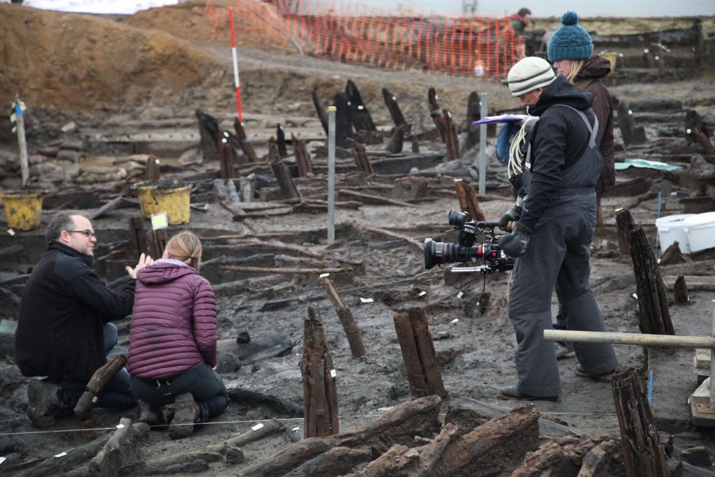 Alice Roberts and Karl Harrison talking in the trench and being filmed. (Lake Constance)