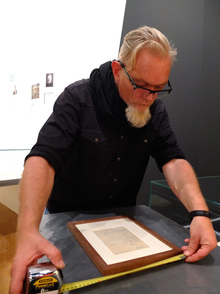 Taking measurements of framed Dr Felix Rey drawing in preparation for hanging for exhibition "On the Verge of Insanity:  Van Gogh & His Illness"